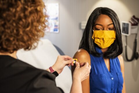 woman receiving a vaccination on right shoulder